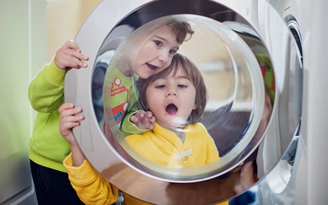kids looking through washing machine