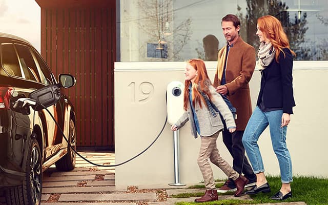 card-family-of-three-charging-electric-vehicle